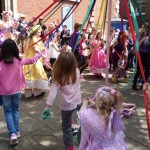 Chorkdren dancing around tte maypole