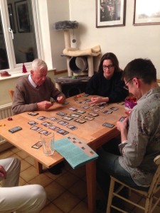 Three generations playing a board gamee.